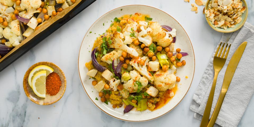 Traybake van bloemkool wortelpeterselie prei en rode ui met harissa kikkererwten kruidige linzen, koriander en amandelschaafsel | Maaltijdbox recepten